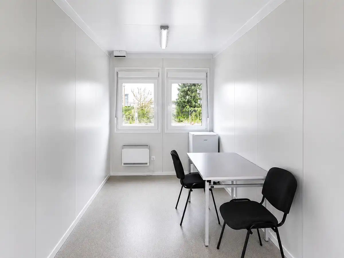 Home Moderner Bürocontainer von Spacetainer mit Schreibtisch, zwei Stühlen und Kühlschrank.